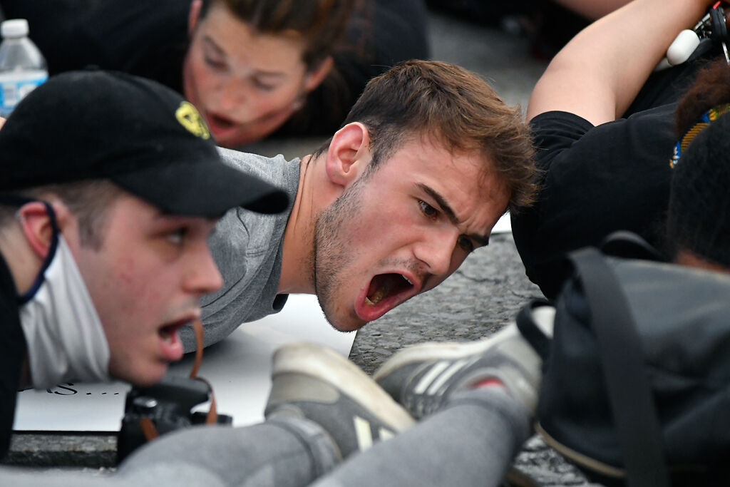 A protester lies on the ground and chants Wednesday in downtown Columbia
